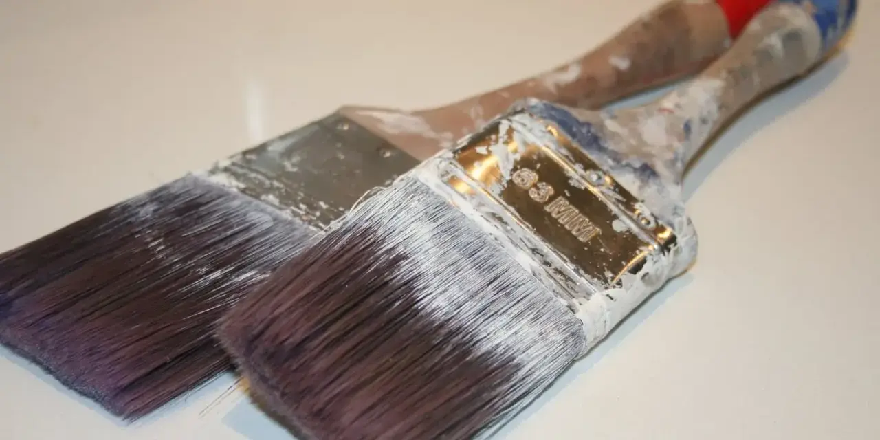 Deux pinceaux usagés, couverts de peinture blanche séchée. Que faire avec ce pinceau sec ?