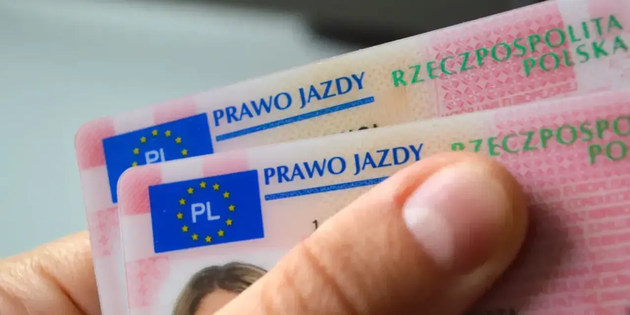 Dłoń trzyma polskie prawa jazdy. Widoczne napisy "PRAWO JAZDY" i "RZECZPOSPOLITA POLSKA" sugerują różne kategorie prawa jazdy.