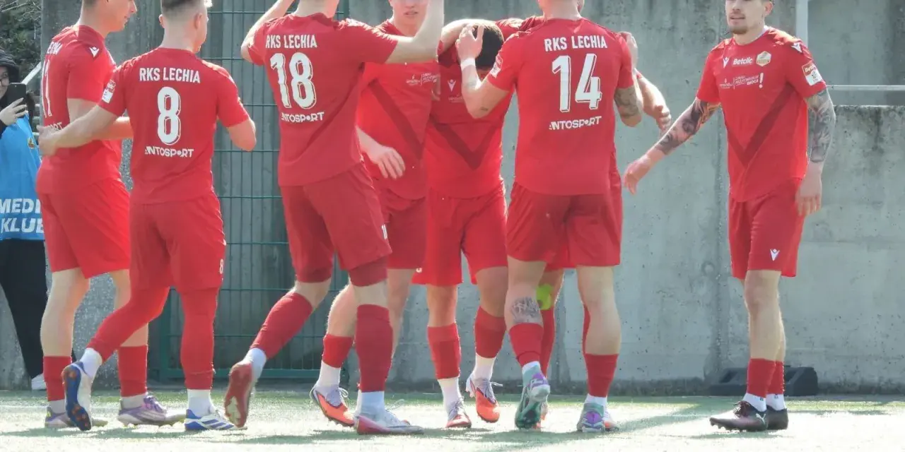 Piłkarze RKS Lechia świętują, jeden z nich, Jakub Biernat, cieszy się z sukcesu.