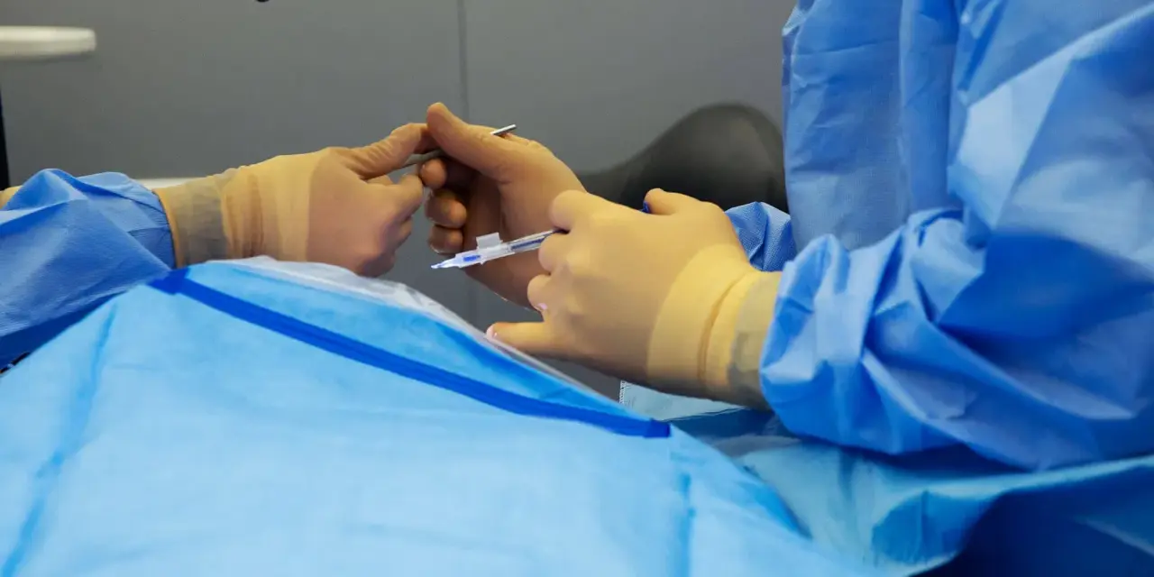 Mani guantate eseguono un intervento chirurgico oculare, forse un piombaggio retina, con precisione.