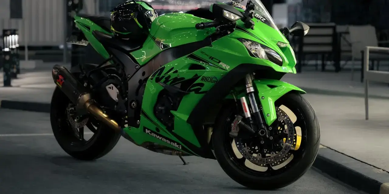 Japoński motocykl Kawasaki Ninja ZX-10R w jaskrawym zielonym kolorze, z kaskiem na siedzeniu, gotowy do nocnej jazdy.