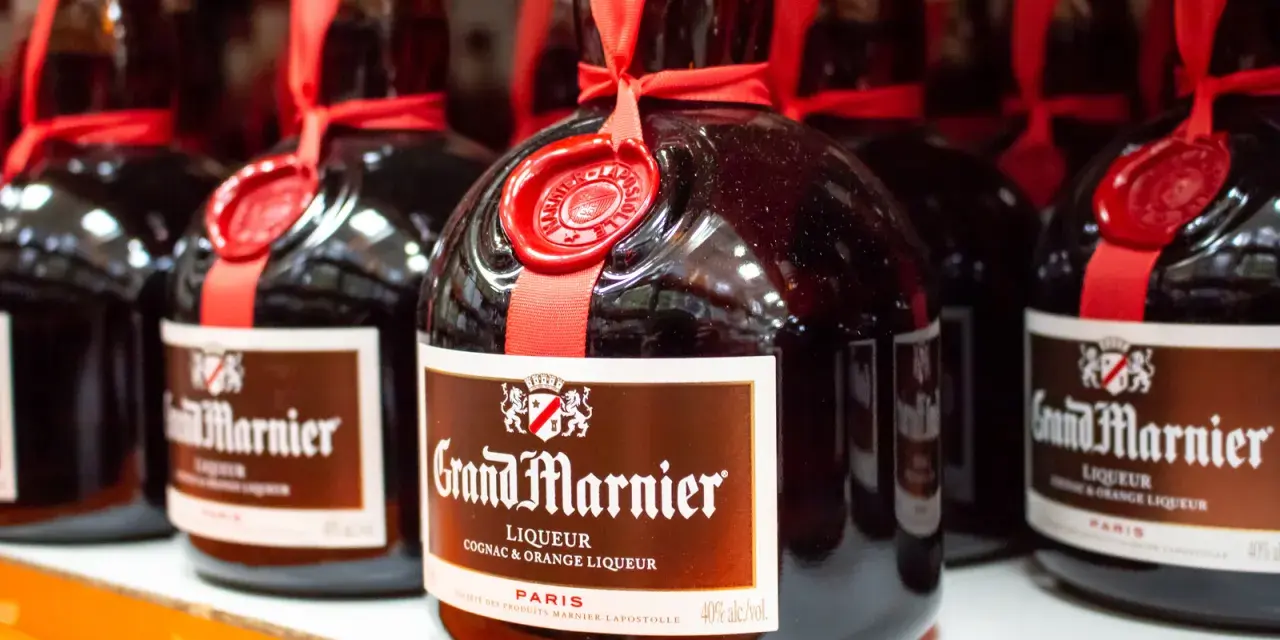 Butelki likieru Grand Marnier, idealnego do margarity. Czerwona wstążka i pieczęć dodają elegancji.