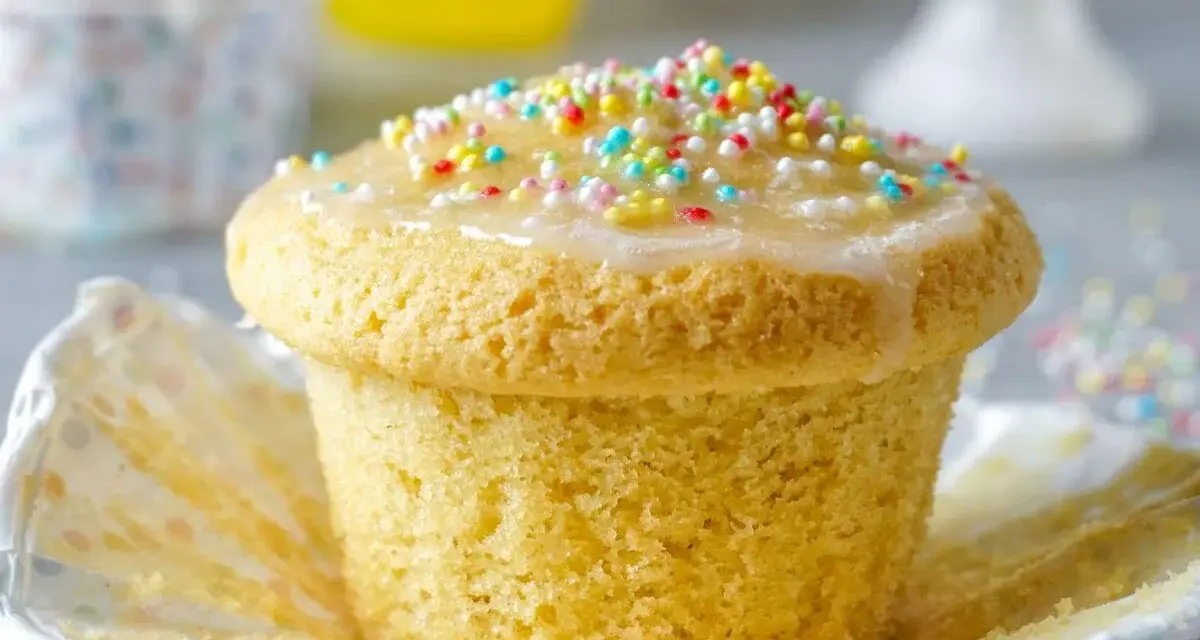 Ein Fanta-Muffin mit Zuckerguss und bunten Streuseln, bereit zum Genießen.