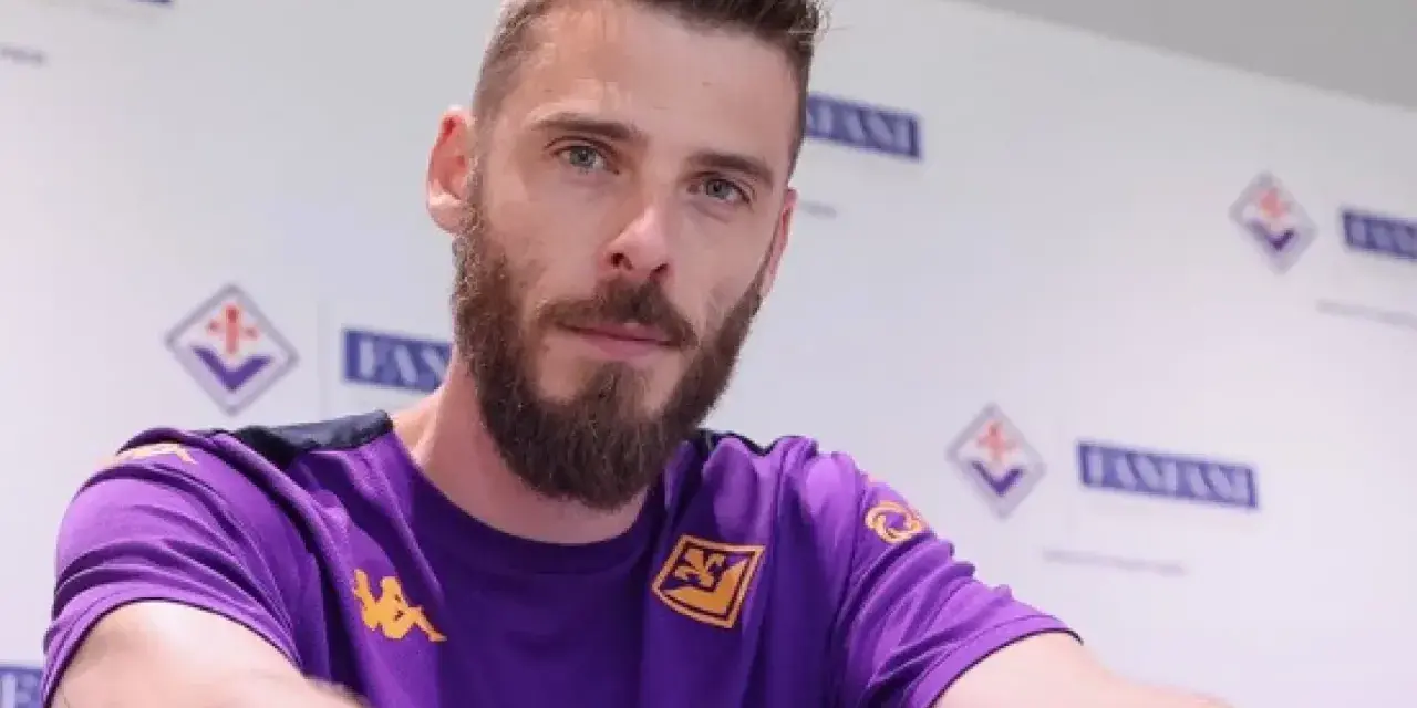 David de Gea, con barba y camiseta morada, posa ante un fondo con logos.