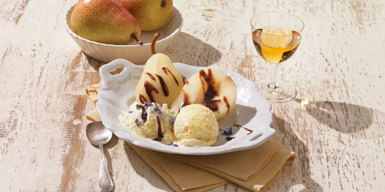 Gegarte Birnen mit Schokoladensauce und cremigem Vanilleeis, garniert mit Lavendelblüten. Ein köstliches Birnen Eis Dessert.