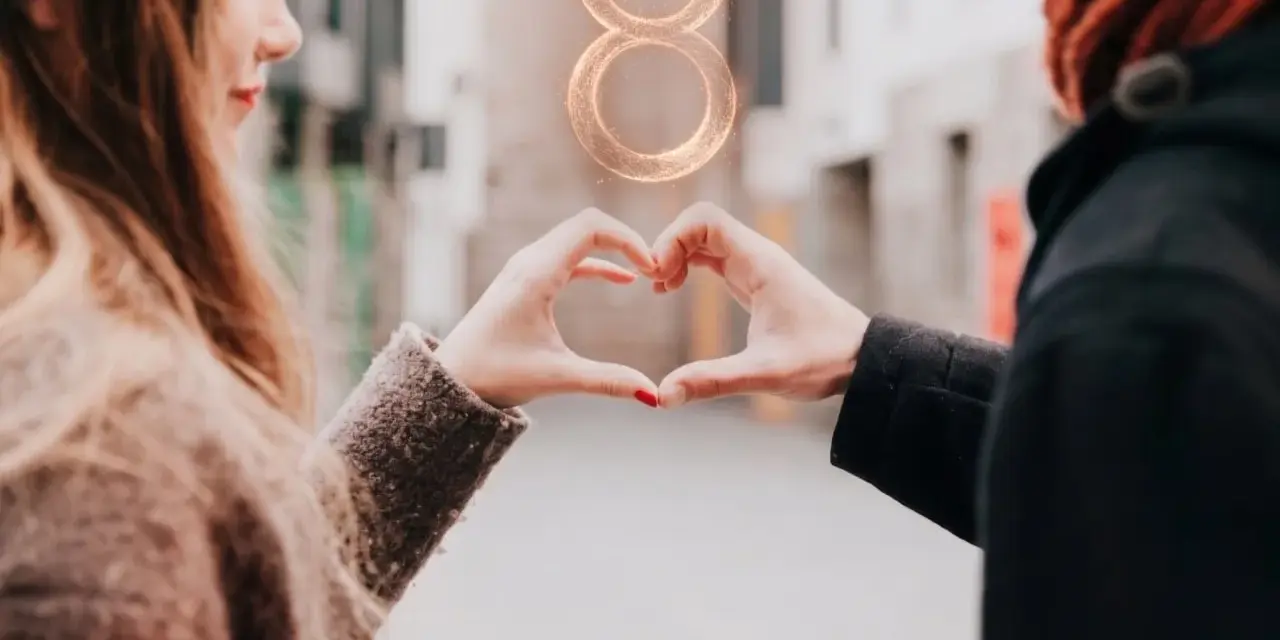 Para z dłońmi tworzącymi serce, nad nimi symbol zodiaku Byk.