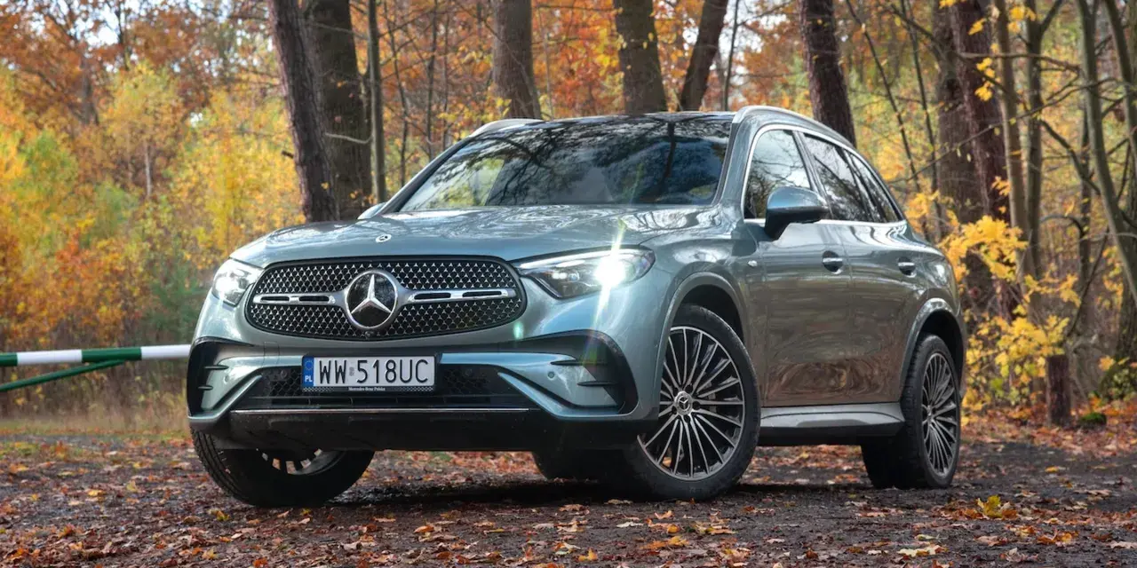 Elegancki Mercedes GLC 300 w jesiennym lesie, otoczony kolorowymi liśćmi.