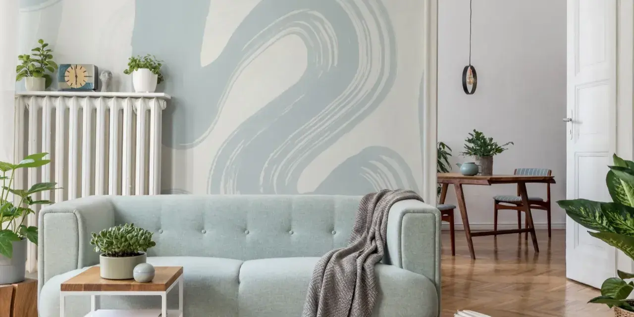 Miętowa kanapa i tapeta w stylu baby blue tworzą przytulną atmosferę.