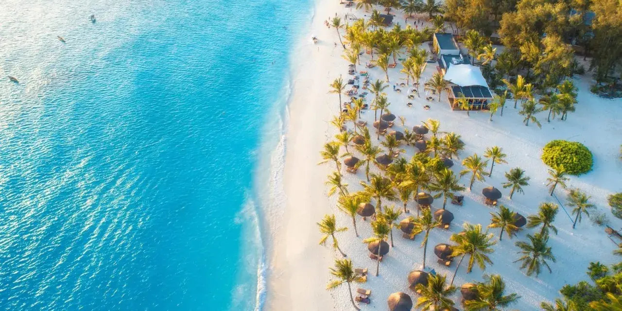 Rajska plaża na Zanzibarze z turkusową wodą, białym piaskiem, palmami i luksusowym resortem. Idealne miejsce, kiedy na Zanzibar.