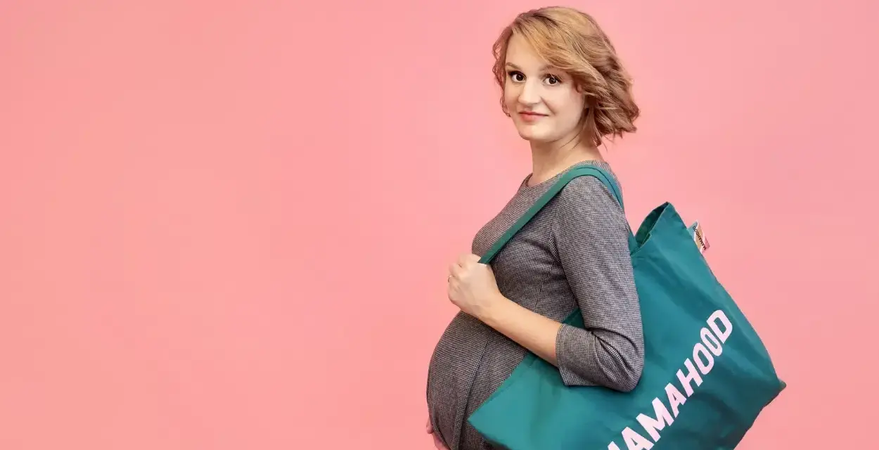Przyszła mama z torbą "Mamahood" gotowa na wyprawkę do szpitala.