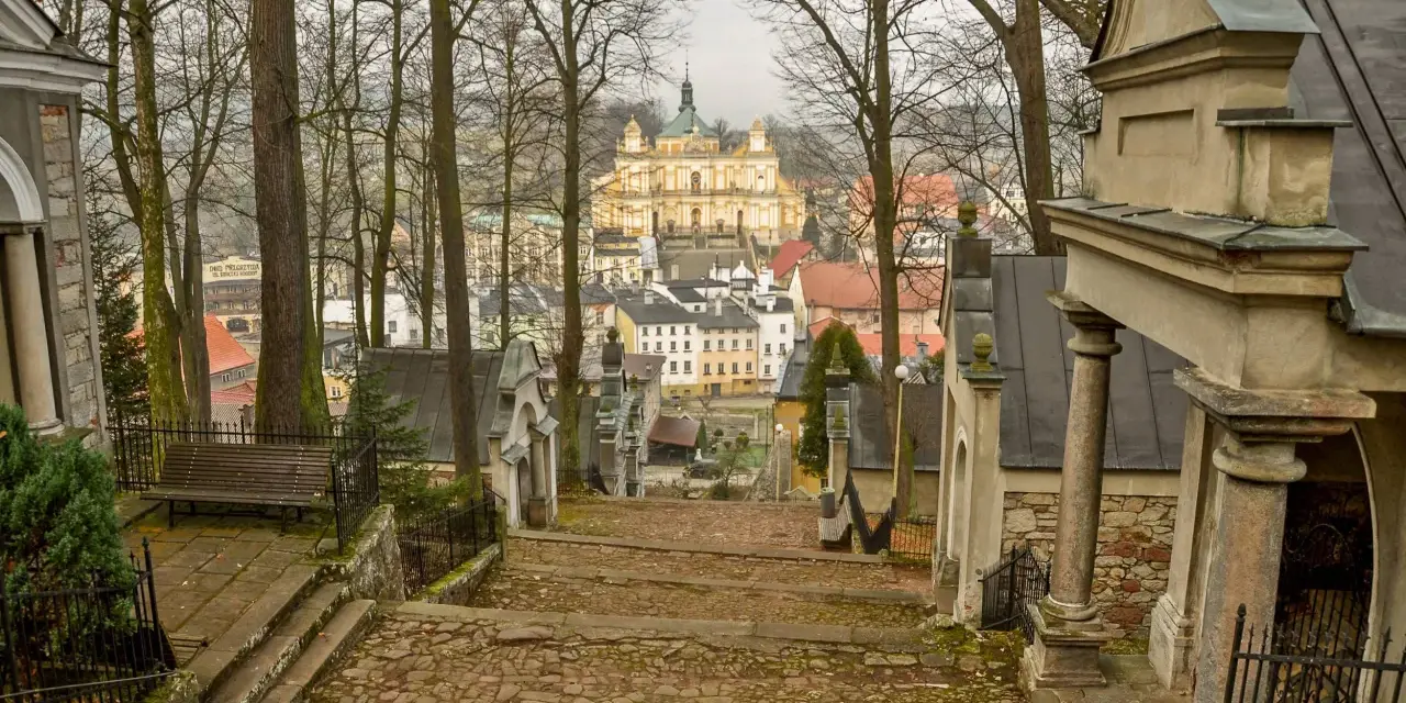 Kamienne schody prowadzą do barokowej bazyliki na wambierzyckiej kalwarii. W oddali widać miasteczko.