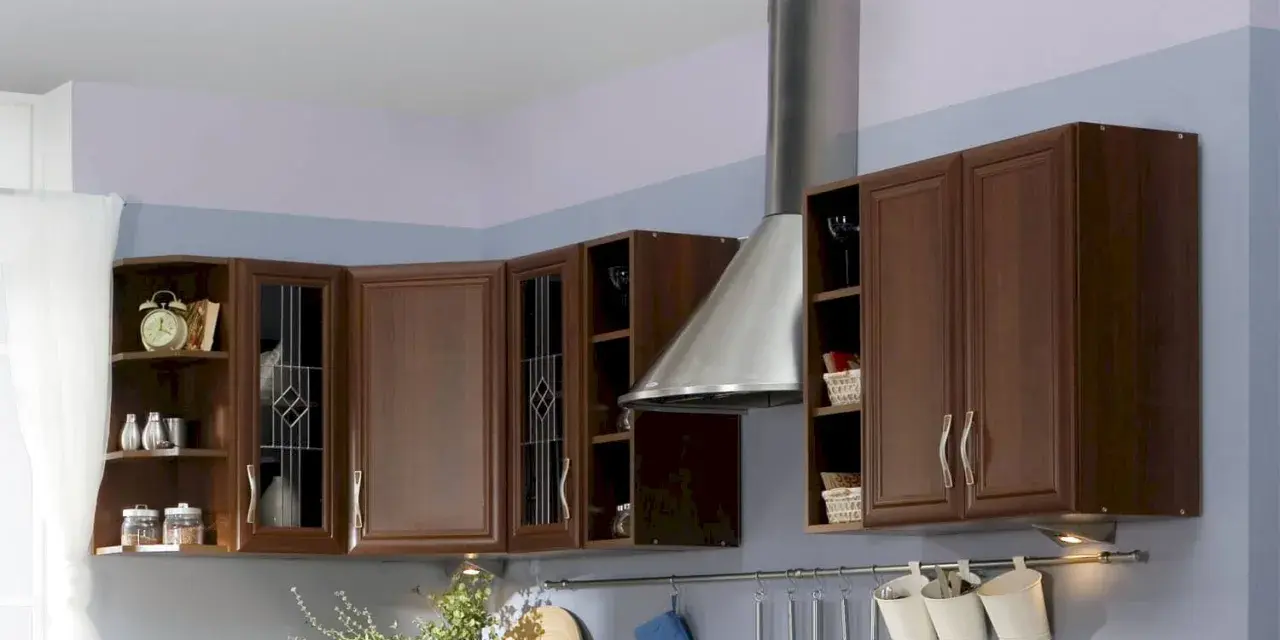 Jasne ściany w kuchni z brązowymi meblami tworzą przytulną atmosferę. Delikatny fiolet i błękit na ścianach dodają elegancji.