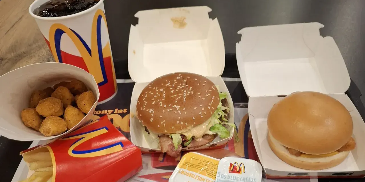 Zestaw McDonald's: burger, frytki, nuggetsy, napój i sosy.