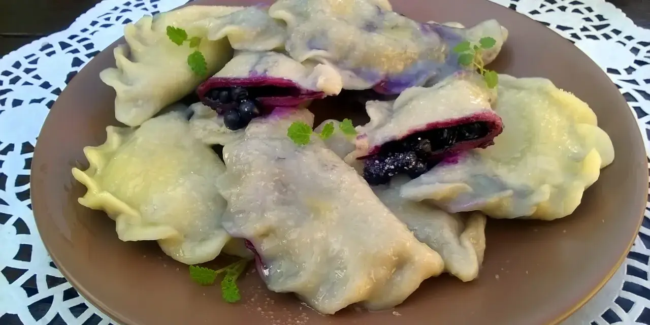 Pyszne pierogi z jagodami, delikatne i pełne owocowego smaku. Idealne na deser lub śniadanie.