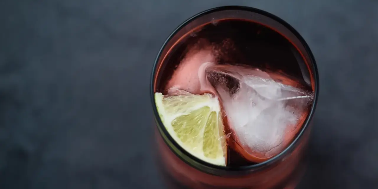 Czerwony drink z lodem i limonką. Idealny do degustacji z brandy Kazbek Peak, odkryj nowe smaki!