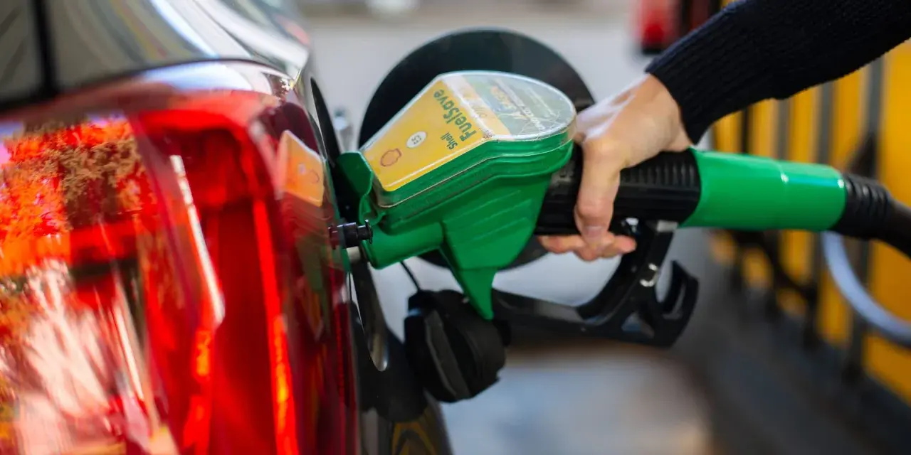 Tankstelle: Eine Hand betankt ein Auto mit dem grünen Zapfhahn. So behältst du im Blick, wie viel verbraucht dein Auto.
