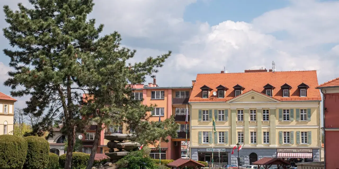 Rynek w Sobótce z kamienną nawierzchnią, drzewami i kolorowymi kamienicami. Atrakcje turystyczne czekają!