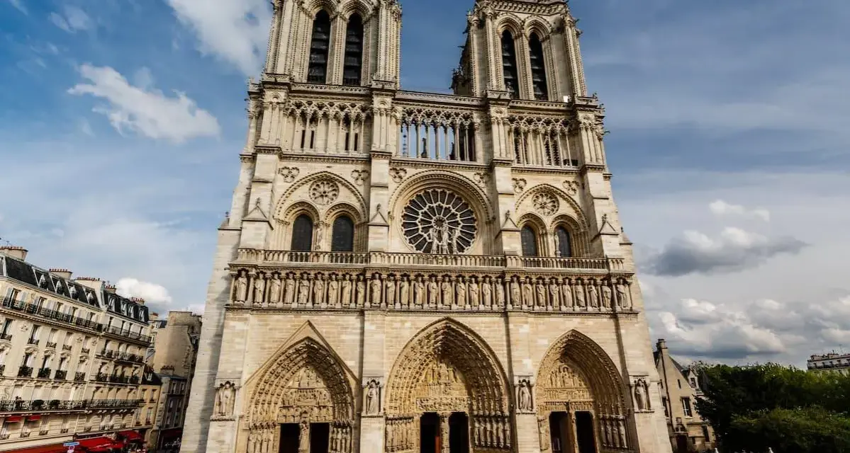 La fachada de Notre Dame, con sus torres gemelas y rosetón, se alza majestuosa. Hoy se puede visitar Notre Dame, un icono de París lleno de historia.