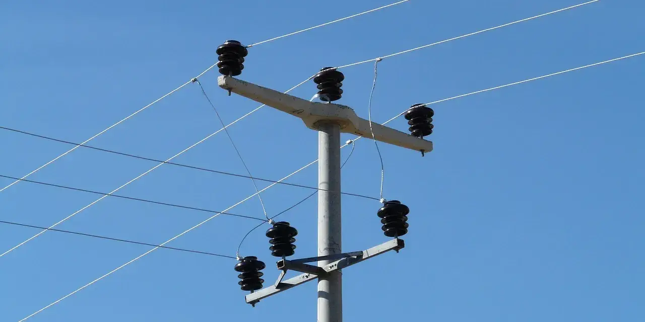 Słup energetyczny z izolatorami, na którym widać przewody elektryczne. Taryfa B23 może być związana z takim właśnie zasilaniem.