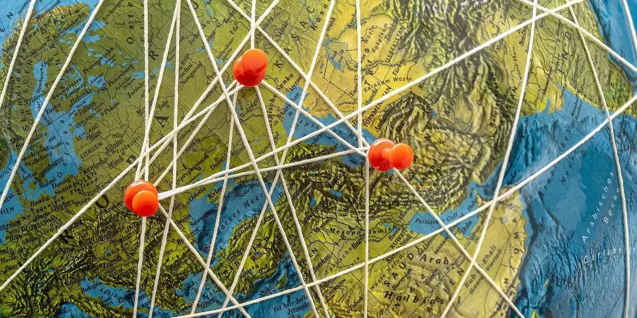 Marzenia o podróżach do Mozambiku? Mapa świata z zaznaczonymi trasami i pineskami symbolizuje plany na wakacje.