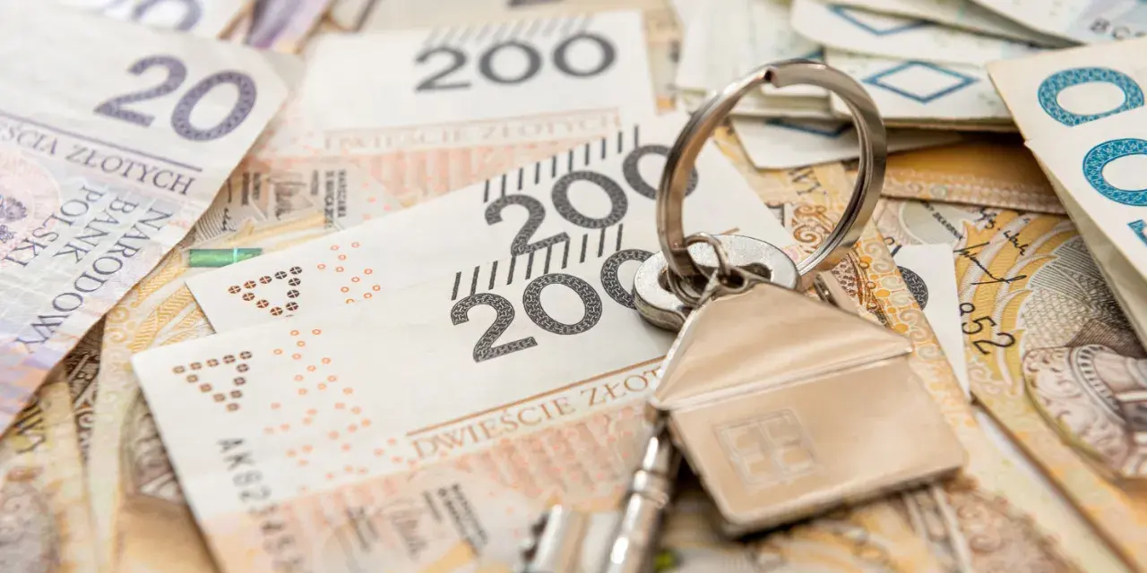 Klucze do domu na stosie polskich banknotów. Może to symbolizuje spłatę kredytu hipotecznego lub inwestycję, a może nawet windykację Santander.