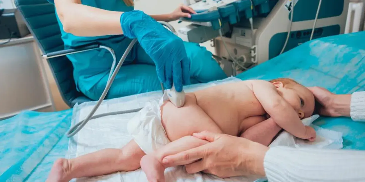 Lekarz wykonuje USG bioderka u niemowlaka. Badanie jest ważne dla prawidłowego rozwoju malucha.