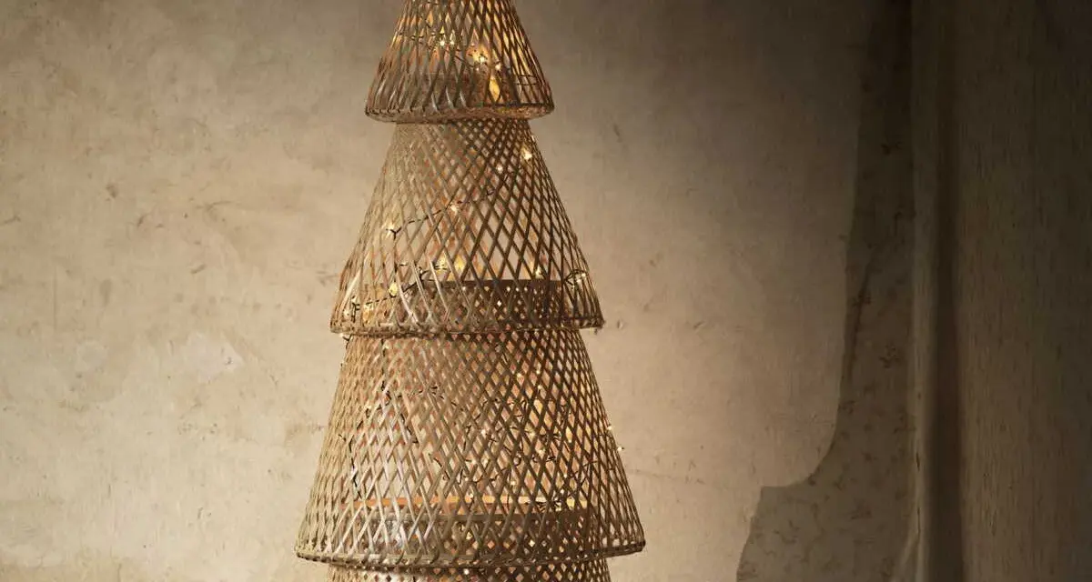 Un sapin de Noël en tissu à faire soi-même, fait de cônes tressés et illuminé de guirlandes lumineuses.