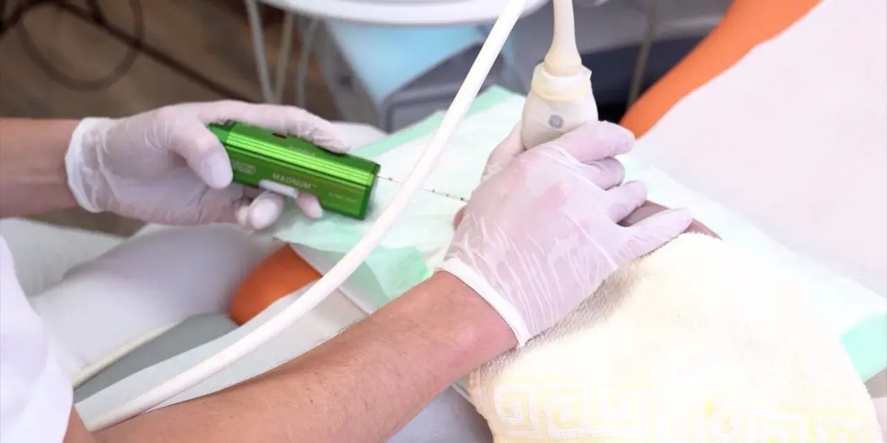 Arzt führt eine Brust-Biopsie mit einem speziellen Gerät durch. Hände in Handschuhen halten die Nadel und den Ultraschallkopf.