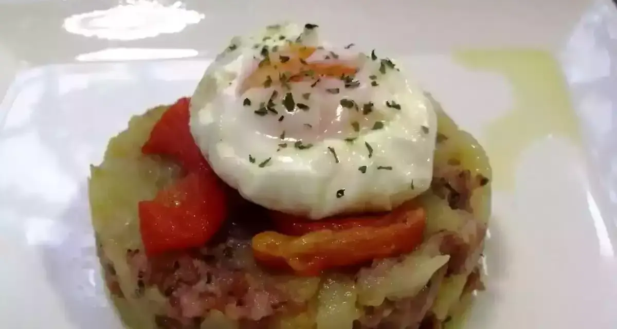 Delicioso timbal de patata con huevo escalfado y pimientos rojos, un plato que te hará chuparte los dedos.