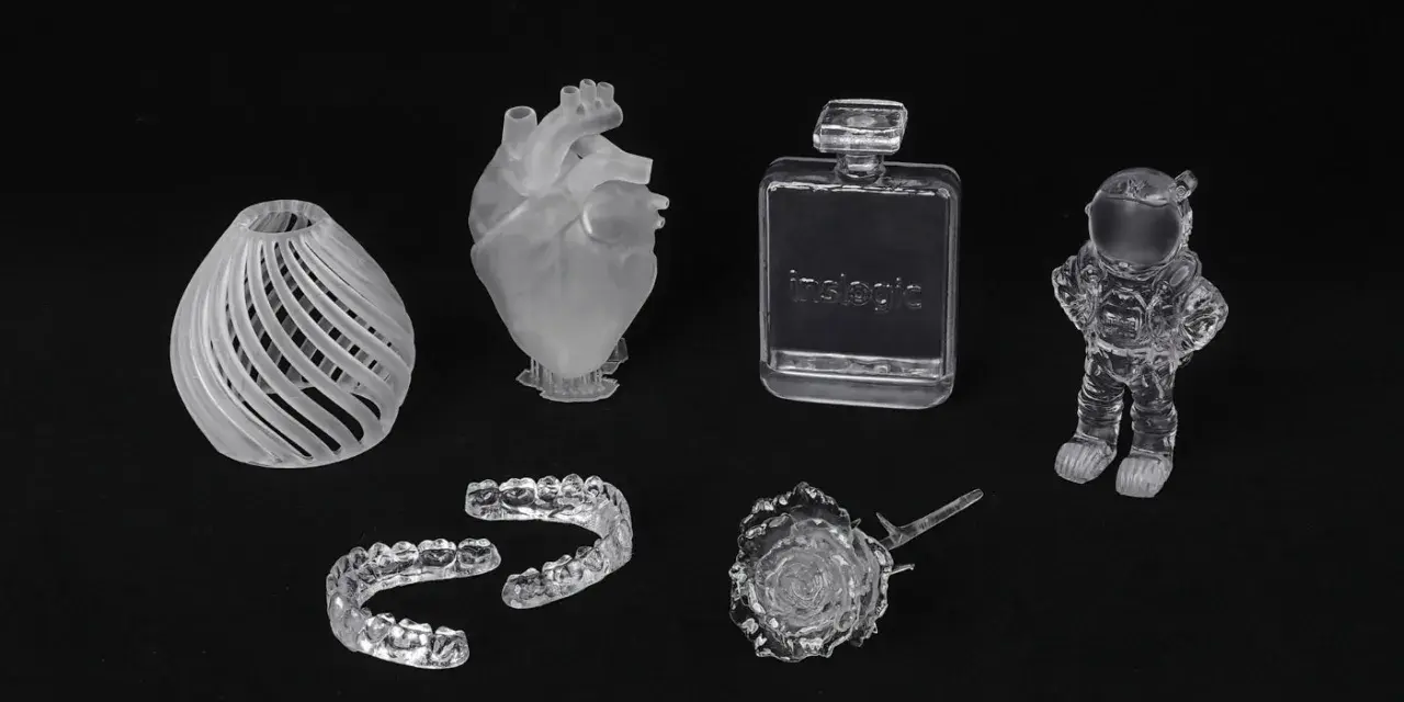 A collection of 3D printed acrylic objects: a vase, heart, dental aligners, perfume bottle, rose, and astronaut.