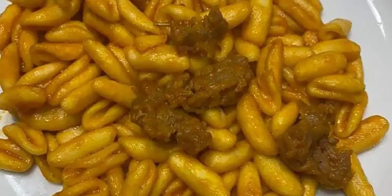Un piatto invitante di gnocchetti alla campidanese, conditi con un sugo ricco e pezzetti di carne saporita.