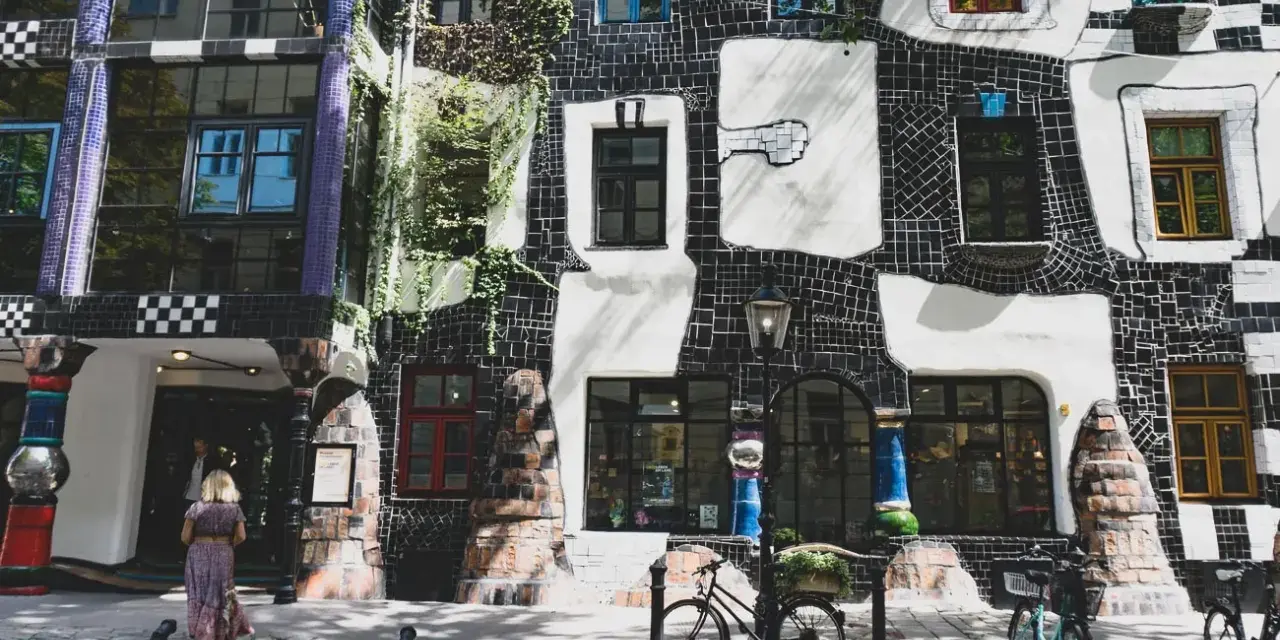 Kolorowy budynek Hundertwasserhaus w Wiedniu. Idealne miejsce, gdzie kupić pamiątki w Wiedniu, pełne unikalnych detali architektonicznych.