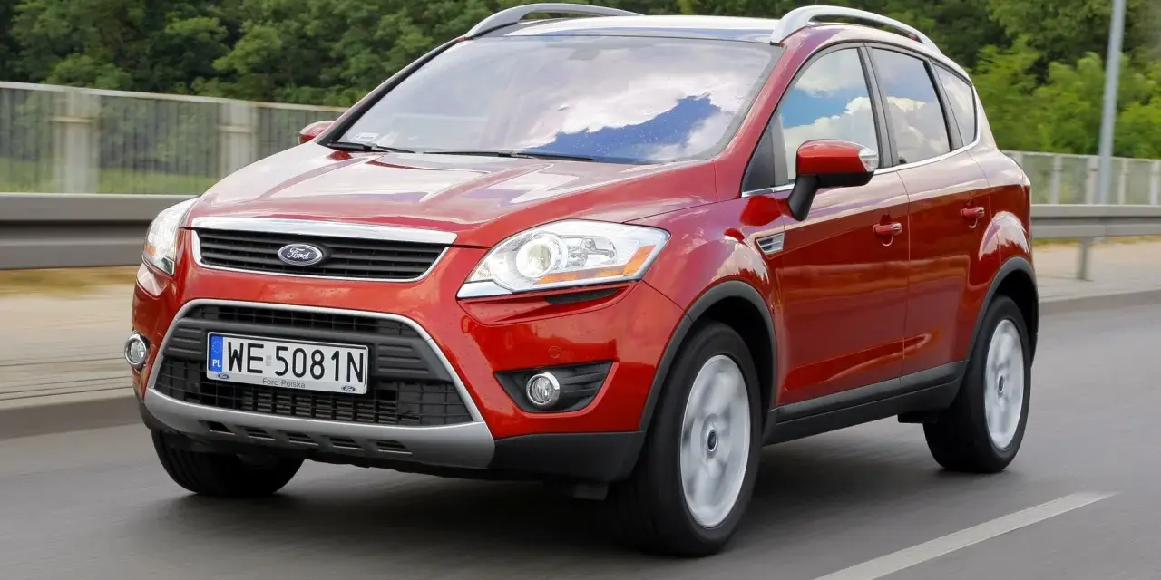 Czerwony Ford Kuga, idealny SUV do 40 tys. zł, jedzie po drodze.