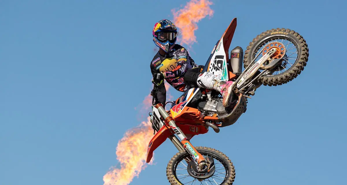 Motociclista Jorge Prado en el aire con llamas saliendo de su moto.