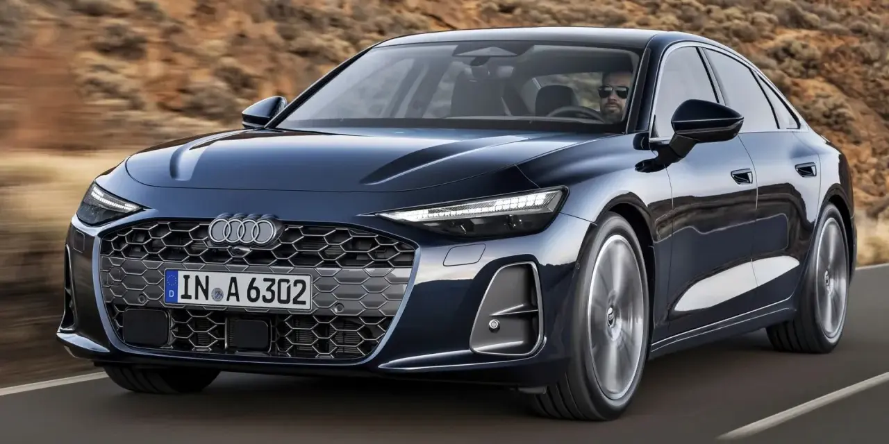 Elegancki, ciemnogranatowy Audi A6 sunie po drodze, z kierowcą w okularach za kierownicą.
