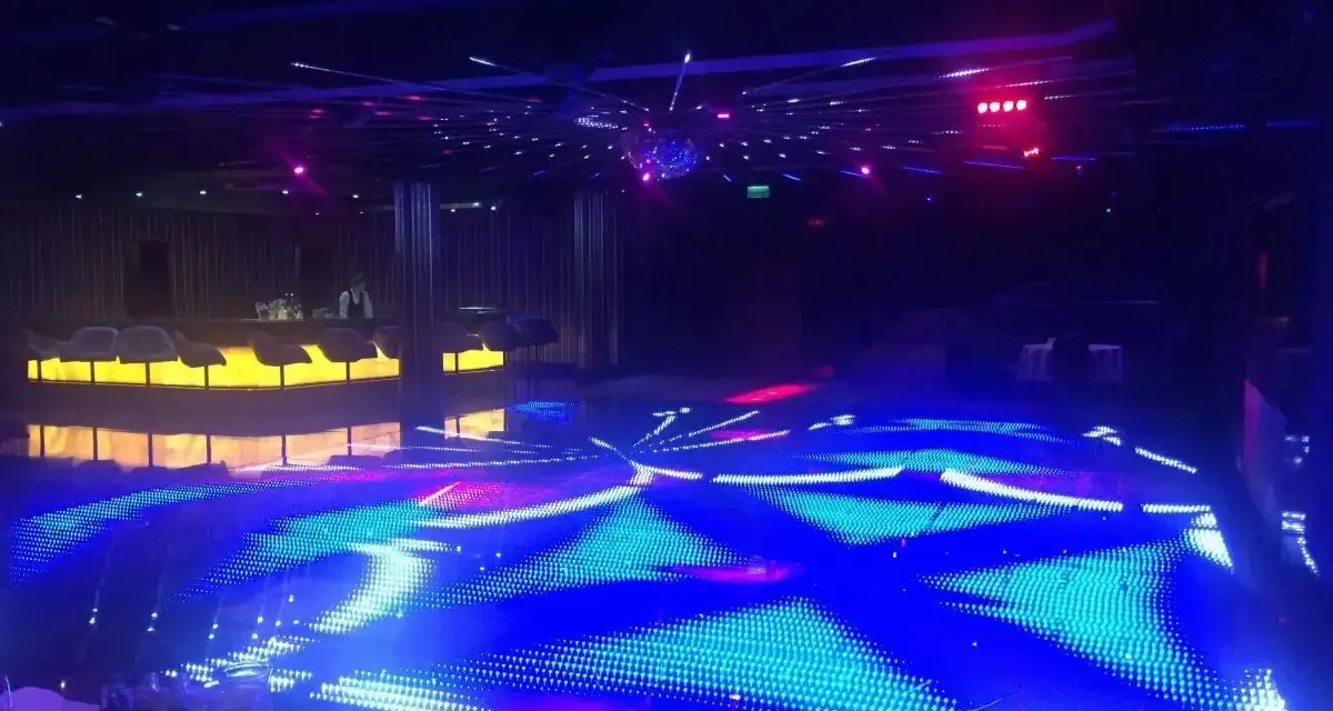 Nowoczesna dyskoteka w Hotelu Gołębiewski Białystok z podświetlaną podłogą i barem.