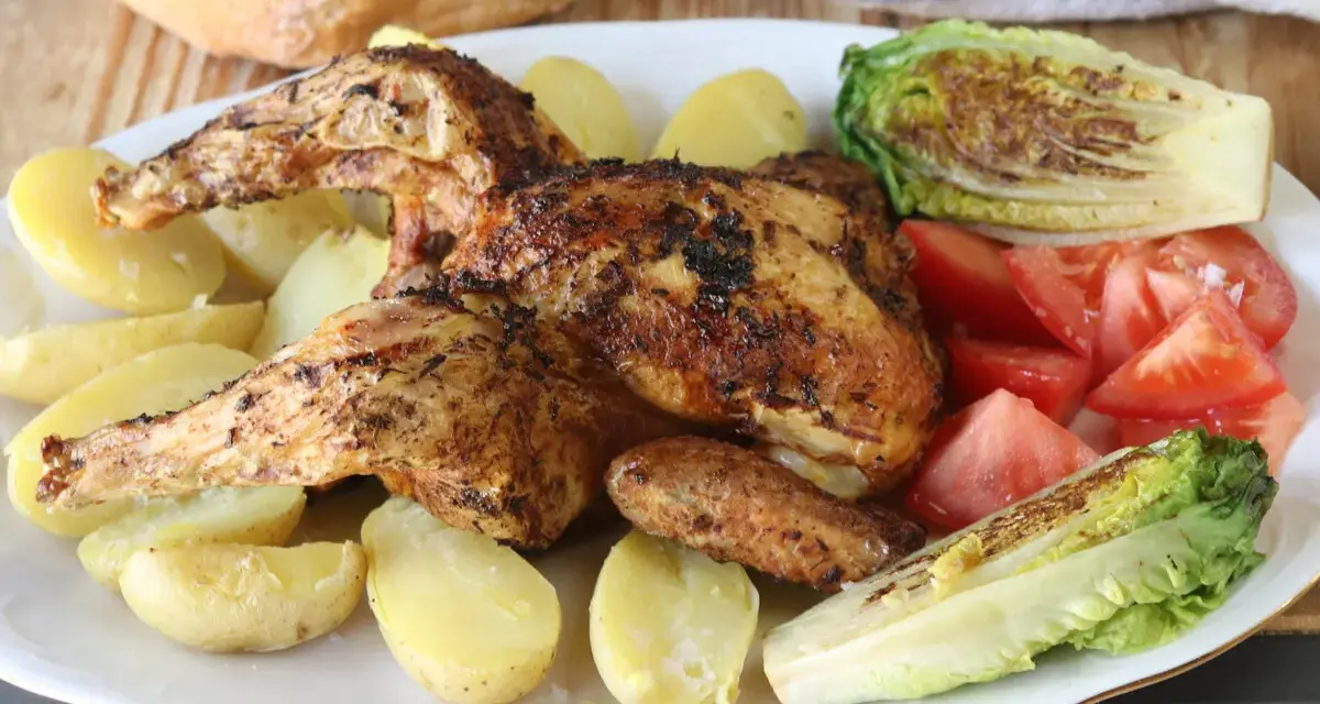 Pollo a la brasa jugoso y dorado, acompañado de papas amarillas, tomates frescos y lechuga a la parrilla. Un festín para los sentidos.
