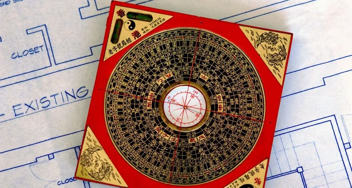 Czerwona siatka bagua feng shui, narzędzie do harmonizacji przestrzeni, leży na niebieskim planie architektonicznym.