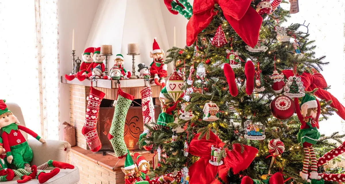 Albero di Natale addobbato con elfi e calze appese al camino. È il momento perfetto per pensare a quando fare albero di Natale!