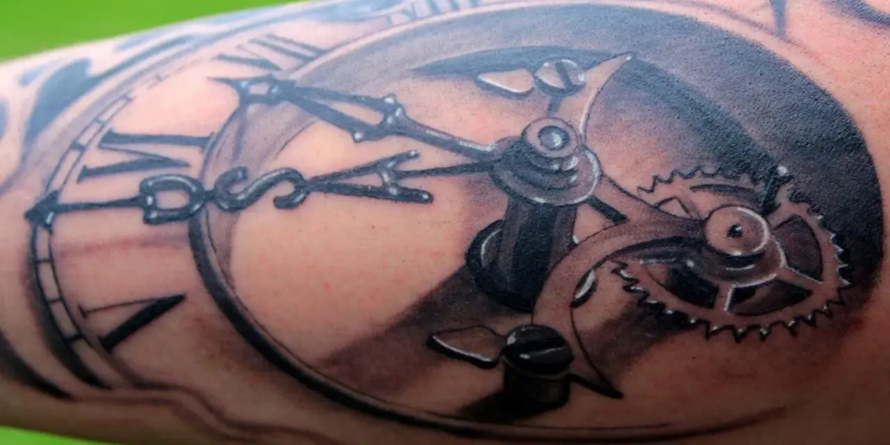 Un tatouage réaliste d'une montre à gousset avec des engrenages complexes. Une œuvre d'art qui témoigne d'une formation dessin tatouage.