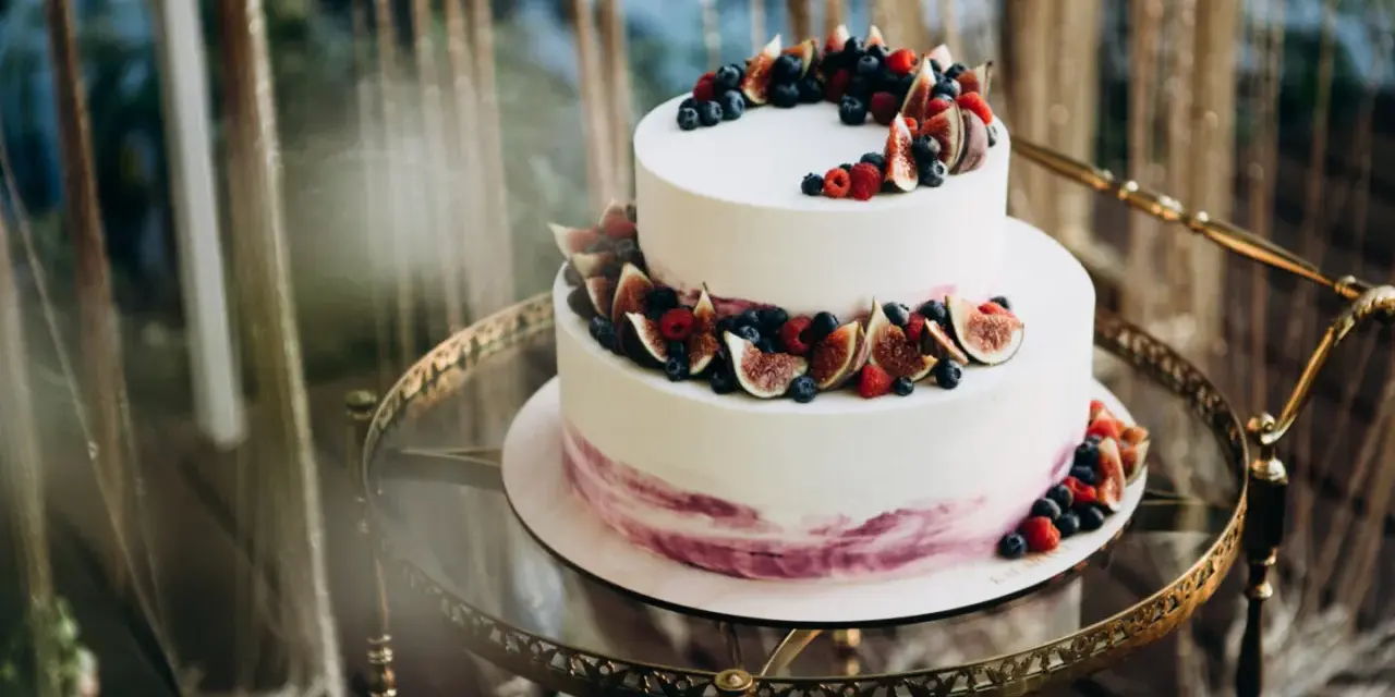 Elegancki tort piętrowy na 40 osób, ozdobiony świeżymi figami, borówkami i malinami. Idealny na wyjątkowe przyjęcie.
