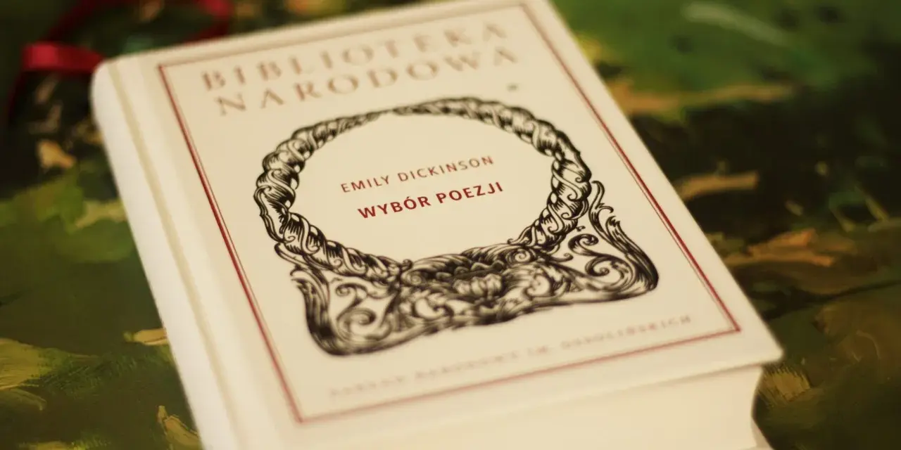 Biała księga z napisem "Emily Dickinson Wybór Poezji" w ozdobnej ramce.