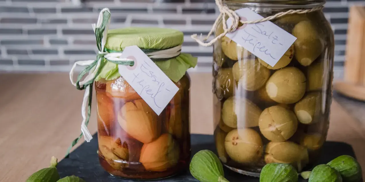 Zwei Gläser mit eingelegten unreifen Feigen, eines in Essig, das andere in Salzlake. Perfekt für unreife Feigen Rezepte.