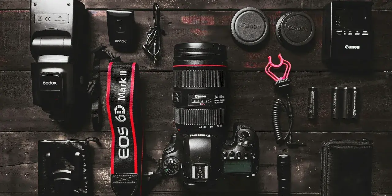 Zestaw do fotografii: aparat Canon EOS 6D Mark II, obiektyw, lampa błyskowa, baterie i akcesoria. Idealny zestaw, jeśli zastanawiasz się, jaki aparat na początek.