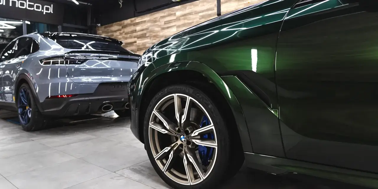 Lśniące, zielone BMW i szare Porsche w garażu. To efekt profesjonalnego auto detailingu, który przywraca blask lakierowi i dba o każdy detal pojazdu.