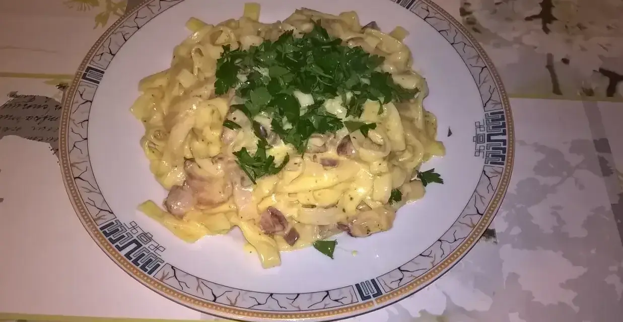 Pyszne fettuccine z boczkiem i pieczarkami, polane kremowym sosem. Idealna odpowiedź na pytanie: jaka śmietana do carbonary?