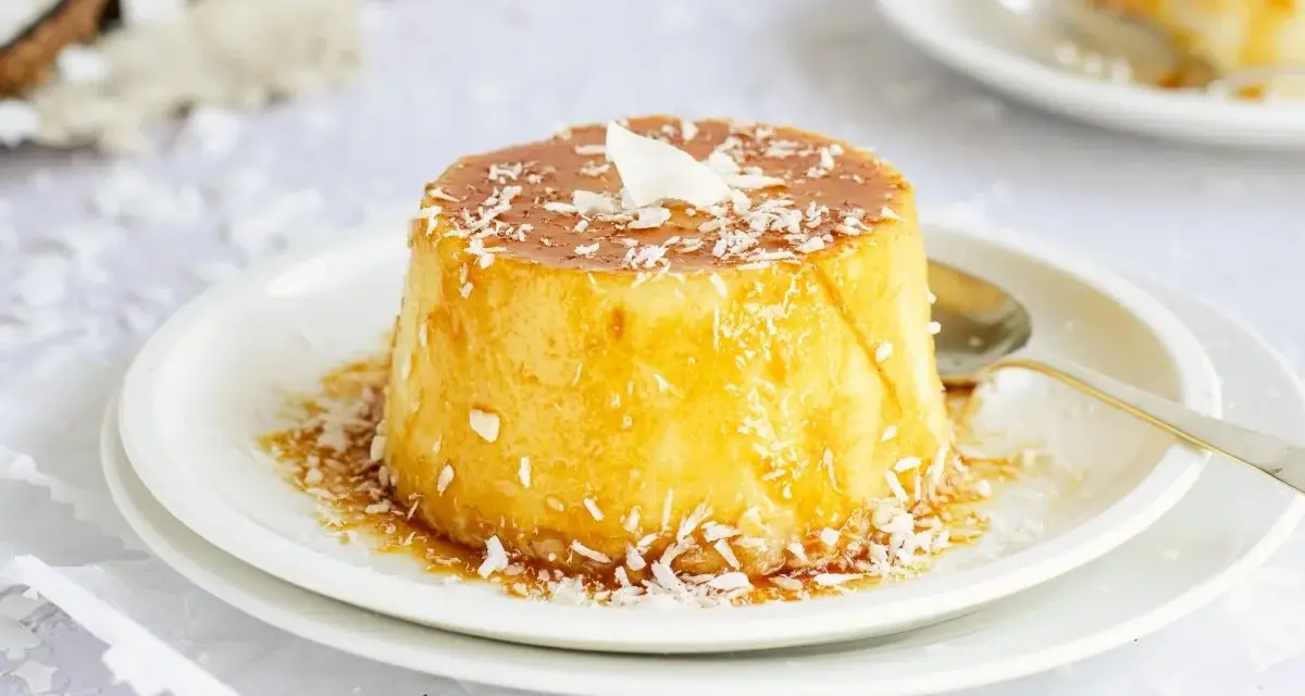 Delicioso flan de coco, cubierto con caramelo dorado y coco rallado, listo para disfrutar.