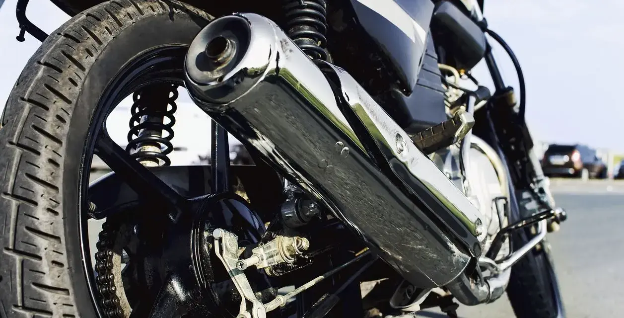 Detalle de la rueda trasera y el escape cromado de una motocicleta. Si te preguntas cuanto cuesta homologar un escape, este podría ser el tuyo.