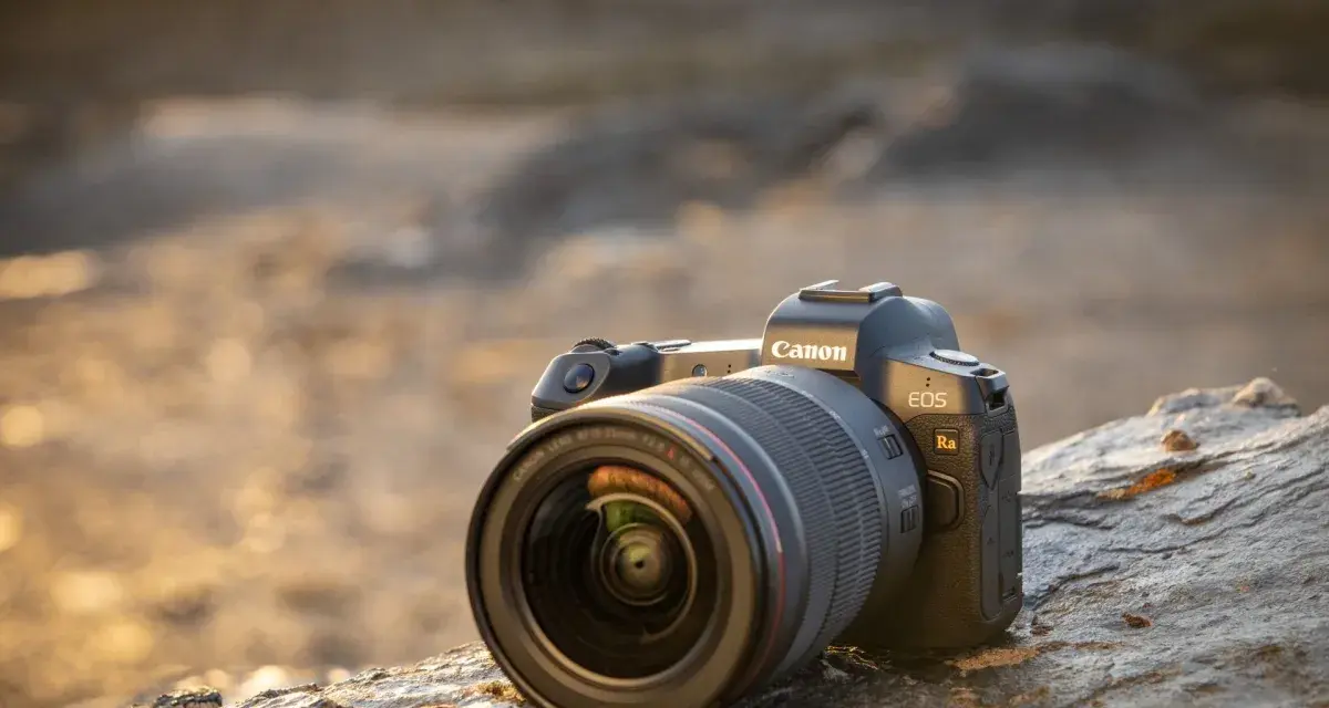 Aparat Canon EOS Ra z obiektywem RF 15-35mm f/2.8L IS USM leży na kamieniu.