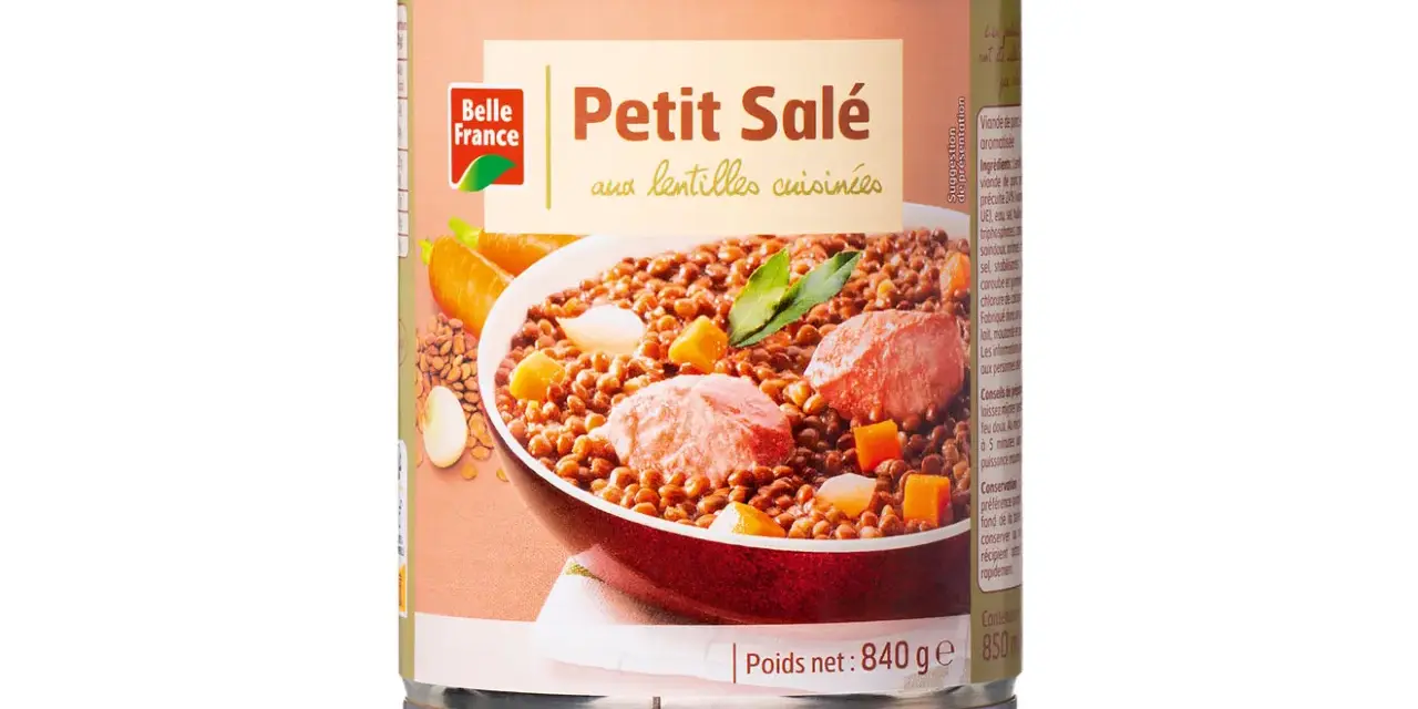 Boîte de petit salé aux lentilles cuisinées, avec des morceaux de viande, des carottes et des dés de légumes.